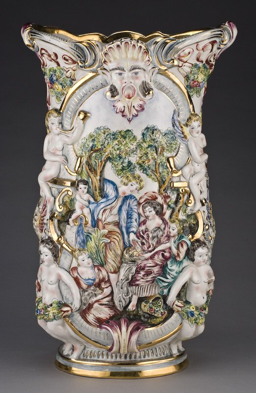 Large Capodimonte vase having raised figural: decoration, each side with a bearded male face, the body decorated with raised women and cherubs, marked for Capodimonte, crown over "C" in gold under glaze. 23.25"H x 14.5"W x 9.75"D, Circa - Late 19