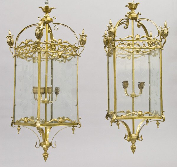 Pr. Louis XVI style bronze and glass lanterns: having a foliate crown over a arched top with acanthine finials to the corners, the four beveled and foliate etched glazed panels enclosing a four light fixture. 49"H x 26"W, Circa - 20th C.
