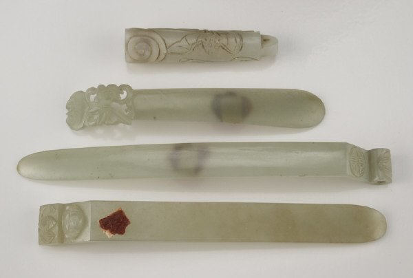 (4) Chinese Qing jade pieces, including: (3): hair pins finely carved to depict flowers and bats; (1) feather holder finely carved to depict a bat in clouds. Longest: 6"L Circa - 19th C.