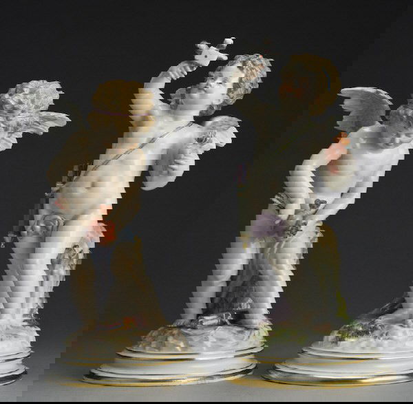 (2) Meissen porcelain figures modeled as cherubs,: (1) holding a heart and a bird, 11.75"H; (1) pulling an arrow from two hearts, 10.5"H; both on a circular stepped gilt decorated bases. Cross swords mark in blue under glaze as well as impressed and i