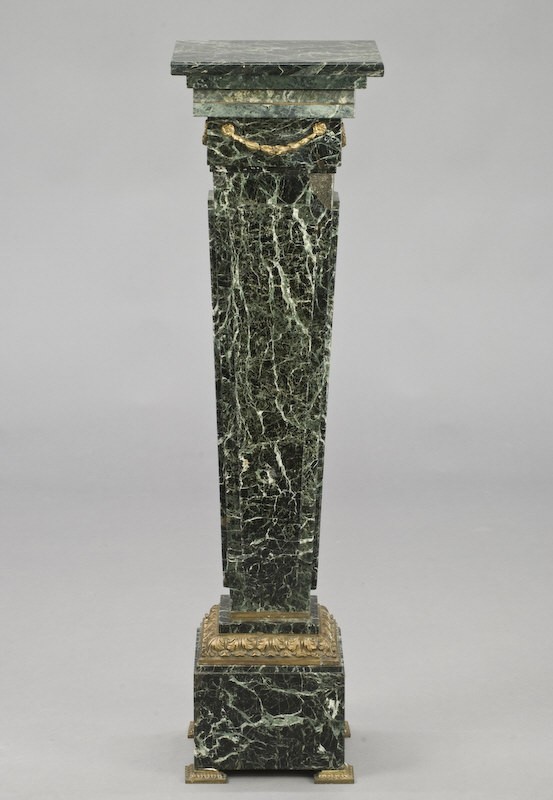 Green serpentine marble pedestal with ormolu: mounts, the square top over a tapered square column with raised panels, on a square plinth with acanthus ormolu frame and square ormolu feet. 44"H x 12" Sq., Circa - First quarter 20th C.