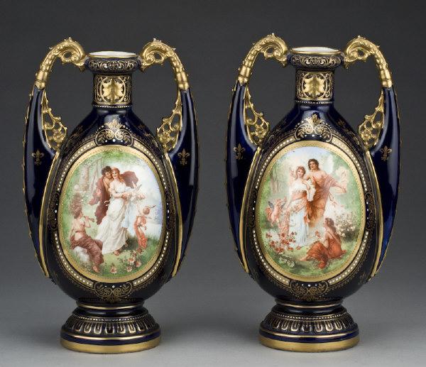Pr. Royal Vienna porcelain vases, the form in the: "Persian" taste with a pierced neck and handles, the cobalt body with a central reserve hand painted with a romantic scene. Under glaze blue beehive marks as well as incised and over painted numerals.