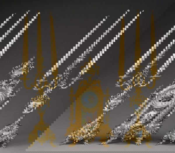 3Pc. Sevres style clock garniture set: the clock case set with porcelain inserts and columns. The matching four light candelabra with removable wreath capped center finials. Replacement digital movement. 14.25"H x 8.5"W x 5.5"D; Candelabra