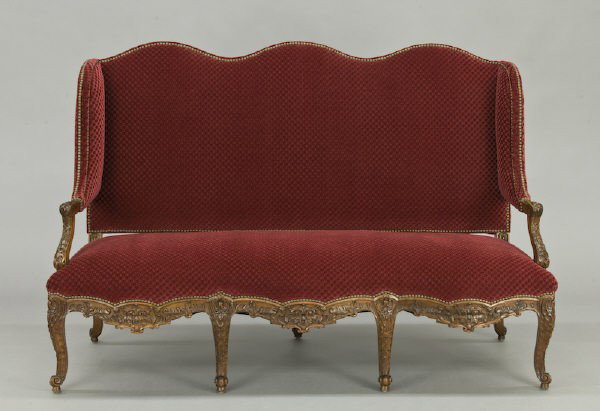 Large Continental walnut settee: with a shaped winged back, having shell and acanthus carved arms and seat rail, resting on cabriole legs. 48"H x 72"W x Circa - Early 20th C.