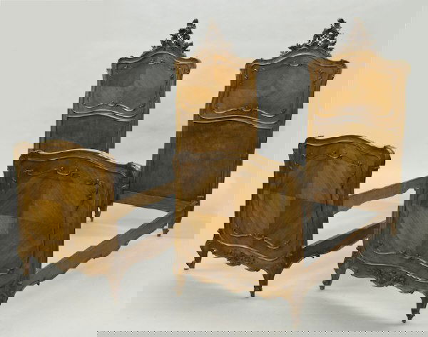 Pr. French Walnut Louis XV style twin beds: with book matched veneer decorated with delicate carved molding, the headboards crested with pierced cartouches. 73"H x 36"W x 84"L. Circa - Late 19th C.