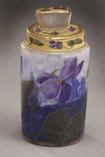 Daum Nancy French cameo perfume,: cylindrical form in mottled blue glass decorated with long stemmed purple violets on green leafy stems, collar and lid with like design on a stippled gold background, signed Daum Nancy, minor flakes t