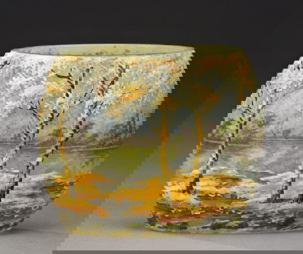 Daum Nancy fall scenic cameo vase,: pillow form in mottled blue glass decorated with a lake scene of tall fall colored trees silhouetted against a green forested shoreline, signed, "Daum Nancy". 3"H, Circa - 1890-1925.