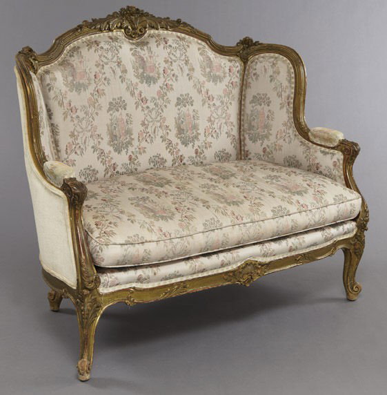 Louis XV style carved gilt wood settee: with a floral carved crest centered by acanthine scrolls, ribbon tied sides, raised on cabriole legs. 43.5"H x 52"W x 24"D, Circa - Late 19th C.