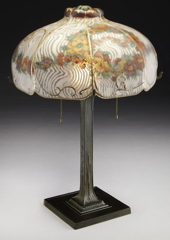 Pairpoint reverse painted table lamp,: Pairpoint reverse painted table lamp, the eight panel shade reverse painted with garlands of flowers and white swirls on a metal base with bronze patination and floral decoration. The base with the, "