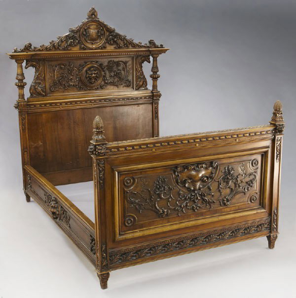 Carved walnut Renaissance Revival bed: Carved walnut Renaissance Revival bed with an elaborately carved headboard featuring a central medallion with lion's head surrounded by scrolling foliage, under a coat of arms flanked by acanthus bran