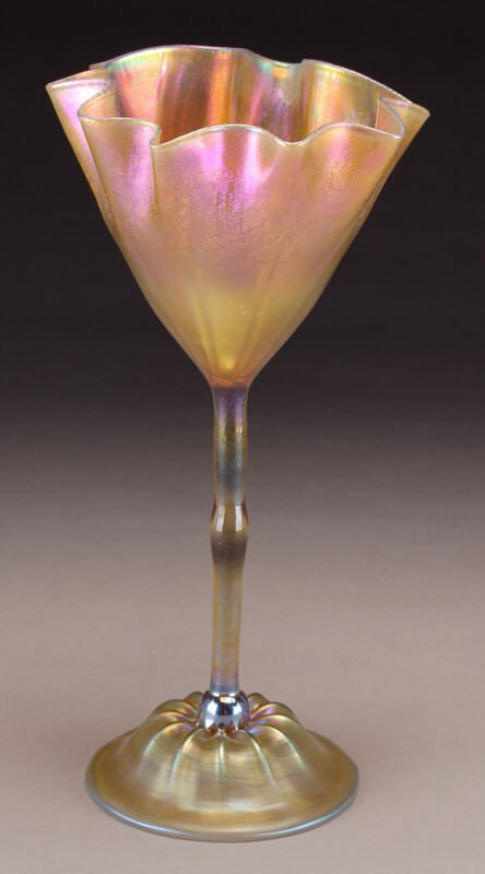 Tiffany gold Favrile glass flower form vase,: Tiffany gold Favrile glass flower form vase, the conical ribbed foot extends up a narrow stem to a free form handkerchief cup with a scalloped rim, accented with rich red overtones. Signed, " 901 - S 