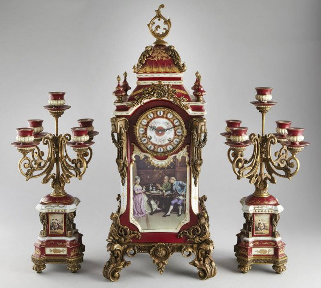 French style ormolu mounted porcelain clock: and candelabra set with Vienna style decoration. Modern brass 2-train balance wheel movement striking on bell. Candelabra: 19"H x 10.75" Sq.; Clock: 28.5"H x 12"W x 10"D, Circa - Late 20th C.