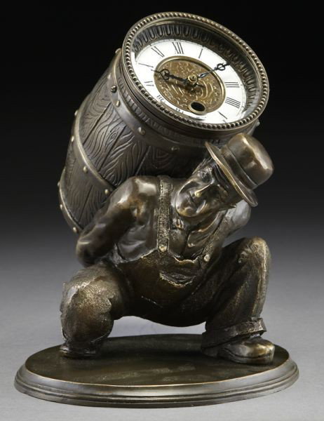Continental patinated bronze figural clock: modeled as a man carrying a barrel, the porcelain dial with Roman numerals. 9.25"H x 7.375"W x 8.375"D, Circa - 20th C.