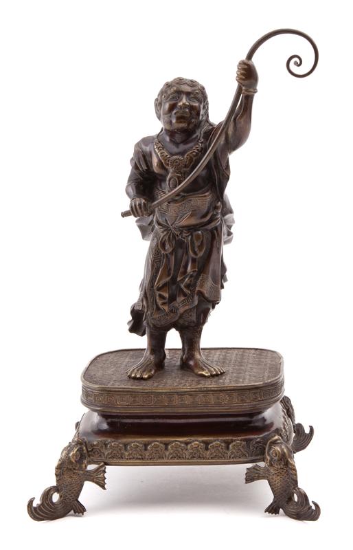 Japanese Meiji bronze immortal,: Japanese Meiji bronze immortal, holding a whip in his hand, raised on a bronze stand with fish feet. PROVENANCE: From the DN Rodinsky Collection. 13.5"H, Circa - 19th C.