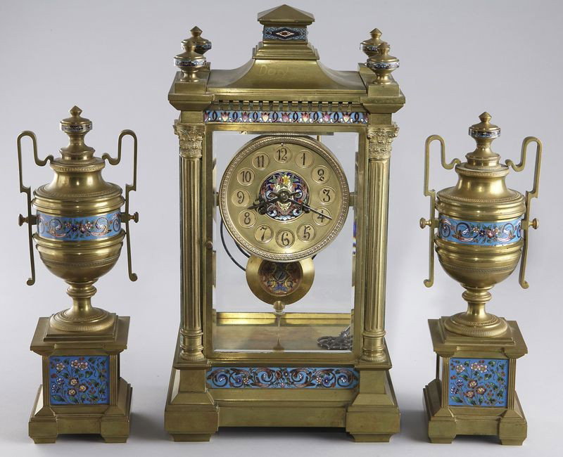 French Vincent bronze and cloisonne 3 pc. clock: set, the crystal regulator having an architectural style case with cloisonne banded elements, the clock dial with Arabic chapters surrounding a foliate cloisonne center with matching pendulum. The mov