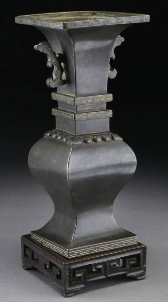 Chinese Qing bronze vase,: having two dragon handles. Six character mark on base, raised on a rosewood stand. Without stand: 8.5"H x 3.75" Sq., Circa - 18th C.