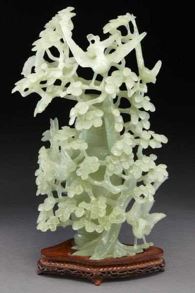 Chinese carved jade urn,: the body of the urn surrounded by carved birds and landscape, raised on a carved wood base. 15"H, Circa - 20th C.