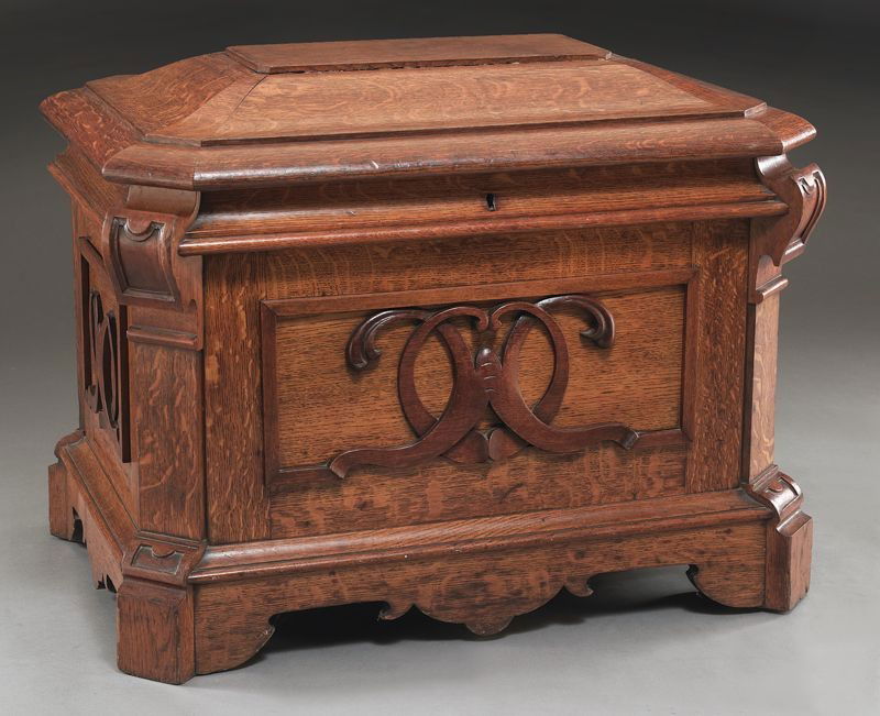 Oak carved cellaret of sarcophagus form,: the front and sides carved with "C" scrolls, the hinged top opening to a felt lined interior. 25''H x 32''W x 22''D, Circa - Late 19th C.