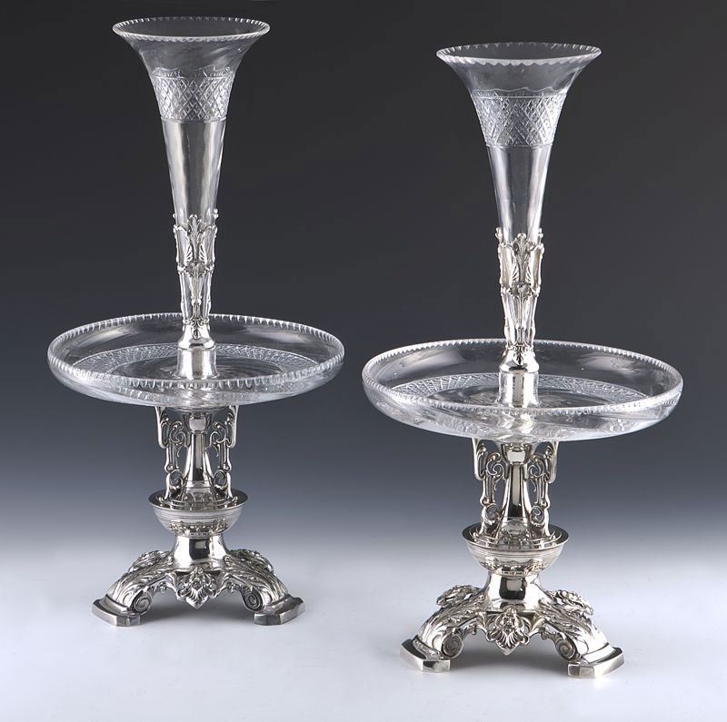 Pr. English silver plate and cut glass epergnes,: each having a trumpet form cut glass insert and a cut glass bowl, raised on three pierced feet decorated with masks and acanthus scrolls. Stamped, "EPNS 5011 2". Marked for Atkin Brothers, Sheffield.