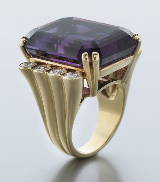 Julius Cohen 18K gold, amethyst and diamond ring: featuring an emerald cut dark purple amethyst, 33.0 grams approximate, accented by eight round brilliant cut diamonds, 2.00 cts. approximate total, F-G color, VS clarity, in an 18K yellow gold mount.