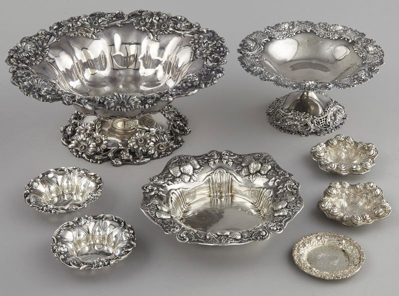 8 Pcs. sterling silver: including: (5) nut dishes, largest: 3.5'' Dia.; (2) compotes, largest: 11'' Dia.; and (1) non-footed bowl, 7.5'' Dia. All featuring repousse florals, the bowl decorated with strawberries. Bearing mark
