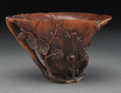 Chinese late Ming carved rhino horn libation cup: (This item may only be sold within the state of Texas. Buyer must present valid Texas Driver's license upon delivery) depicting plum blossoms. 2.75"H x 4.25"W x 3.125"D, Circa - 17th C.