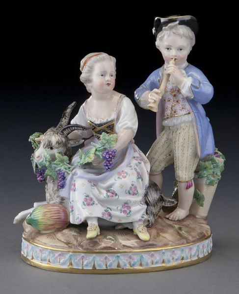 Meissen figural group emblematic of "Autumn",: Meissen figural group emblematic of "Autumn", the boy playing a flute, the girl seated on a goat holding a grapevine, raised on an oval base. Cross swords mark in blue under glaze, as well as incised