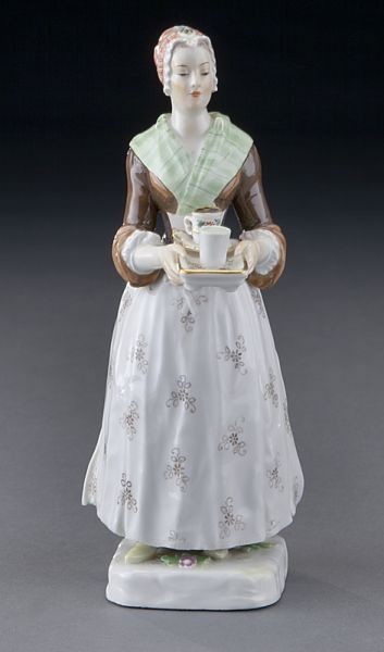 Meissen porcelain figure, "La Bella Chocolatier": Meissen porcelain figure, "La Bella Chocolatier" modeled as a maid carrying a serving tray with a cup of chocolate and a glass of water. Cross swords mark in blue under glaze, as well as impressed and