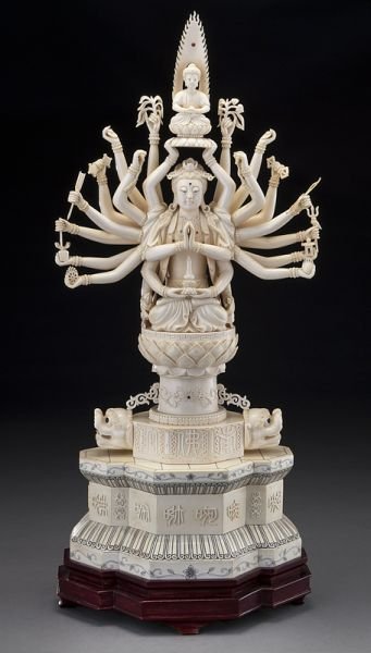 Chinese carved ivory 22-armed Guanyin,: Chinese carved ivory 22-armed Guanyin, (International shipping IS NOT available on this lot. This lot may not be purchased by a resident in the state of California) each arm holding Buddhist instrumen