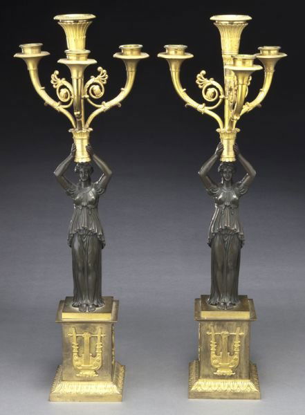 Pr. Empire style parcel gilt bronze candelabra,: Pr. Empire style parcel gilt bronze candelabra, each formed by a classical figure holding aloft four scrolled candle arms, resting on a bronze pedestal applied with harps and decorative accents. 22''H