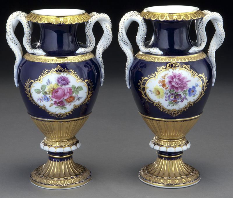 Pr. Meissen porcelain cobalt urns with serpent: Pr. Meissen porcelain cobalt urns with serpent handles, each with a frontal reserve painted with floral bouquets, the whole accented by gilt painted decoration. Cross swords mark in blue under glaze,