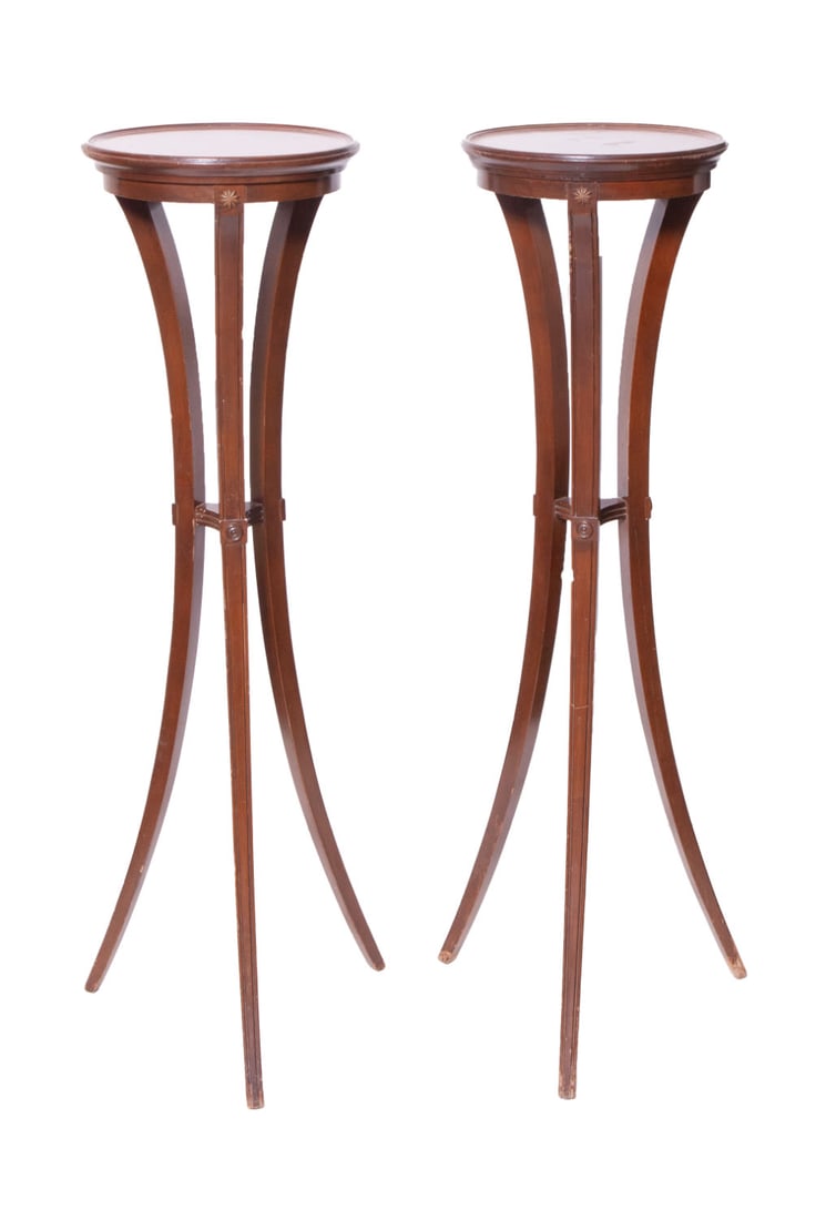 Pair of Mahogany Pedestal Tables: Two tall pedestal tables with carved legs and three floral brass decor. Measuring H 40.5 W 11.5 in Some scratches to the top and legs.