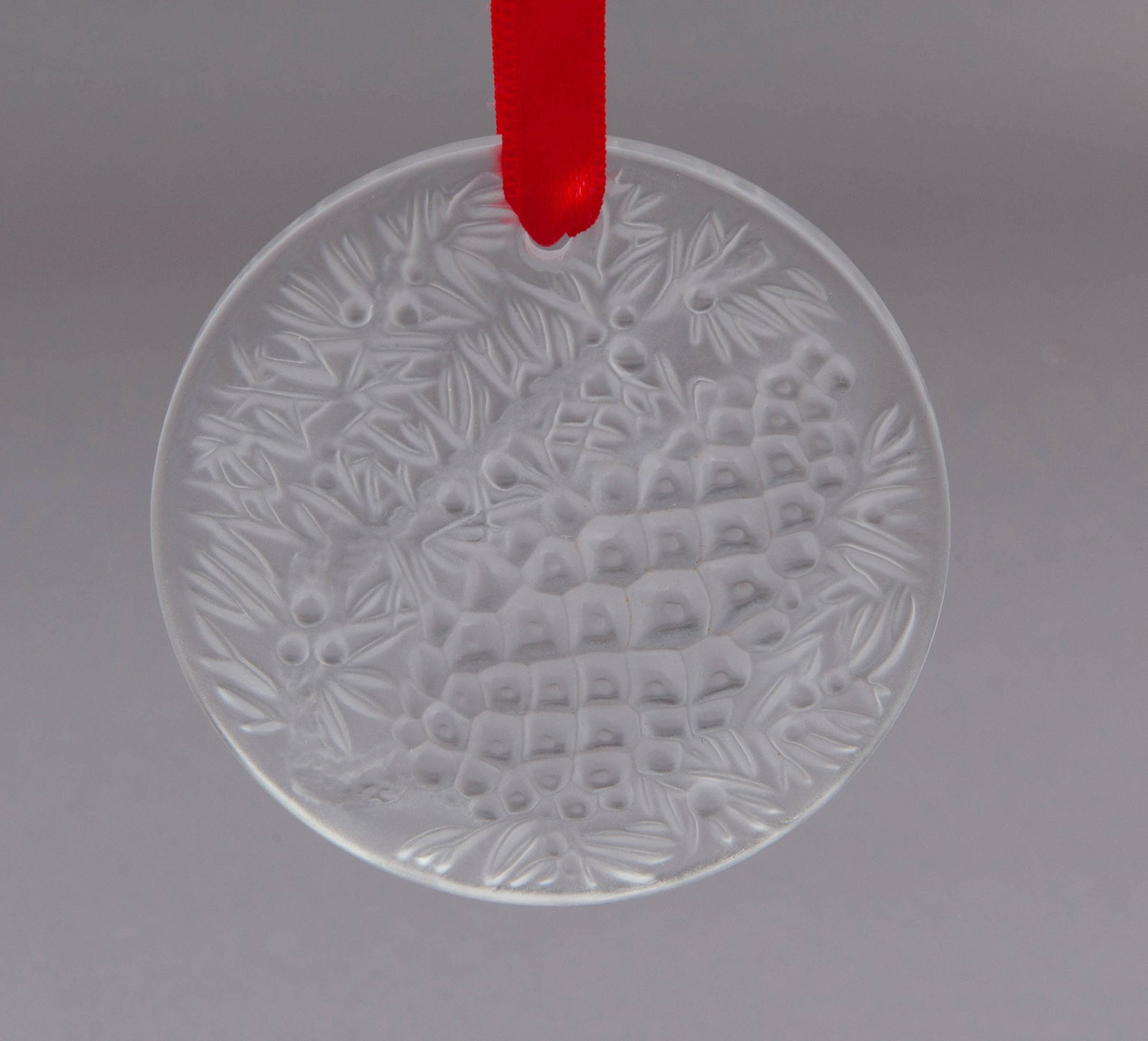 Lalique Seasonal Ornament: Lalique Christmas 2001 ornament, Clear Ponsettia Crystal with red ribbon. With original box. Etched Lalique France on verso. Measuring D 2.75 in Box measuring 3 x 3 in No reserve
