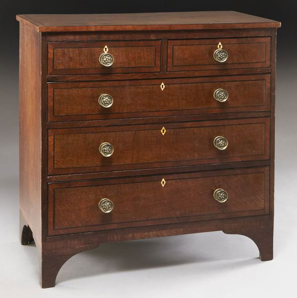 English oak and ebony inlaid chest of drawers,: English oak and ebony inlaid chest of drawers, the top and drawer fronts with ebony framed crossbanding, the two short and three full width graduated drawers with stamped floral brass knobs and ivory