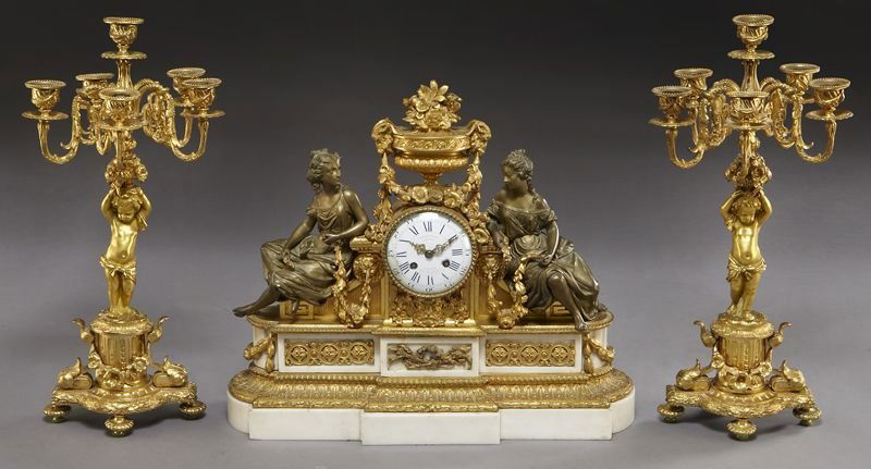 3 Pc. French gilt bronze and marble figural clock: 3 Pc. French gilt bronze and marble figural clock garniture set, the clock topped with a floral urn and flanked by classical beauties, raised on a marble and gilt bronze mounted base, accompanied by (