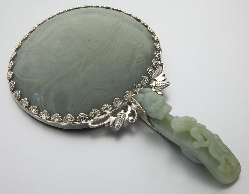 Chinese Qing carved jade hand mirror,: Chinese Qing carved jade hand mirror, the belt buckle handle depicting a dragon, the plaque depicting a floral arrangement. 8"L, Circa - 19th C.