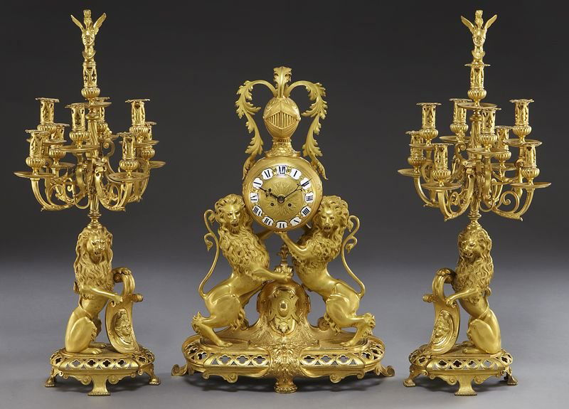 3 Pc. French gilt bronze clock garniture set,: 3 Pc. French gilt bronze clock garniture set, the orb shaped clock topped with an armor helmet, raised by twin lions, on a pierced base, the two 9-light candelabra ensuite. Movement signed "C. Cellier