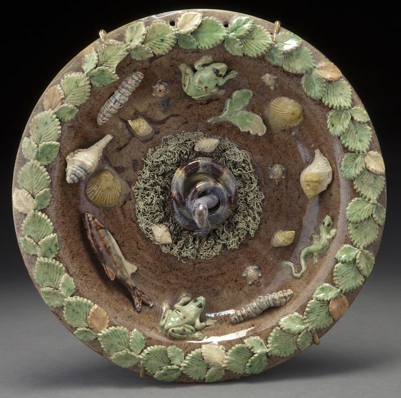 French palissy plate centered by a coiled snake: French palissy plate centered by a coiled snake on a mossy ground, among lizards, frogs, fish, shells and turtles, the rim applied with a border of garland. Unsigned. Possibly by Francois Maurice. 10.
