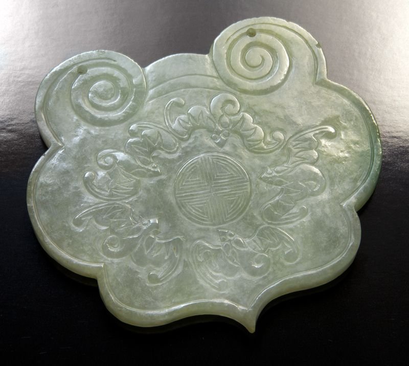 Chinese Qing carved jadeite plaque: Chinese Qing carved jadeite plaque depicting a peach and Buddha's hand, the verso depicting five bats and longevity characters. 3"H x 3.25"W, Circa - 19th C.