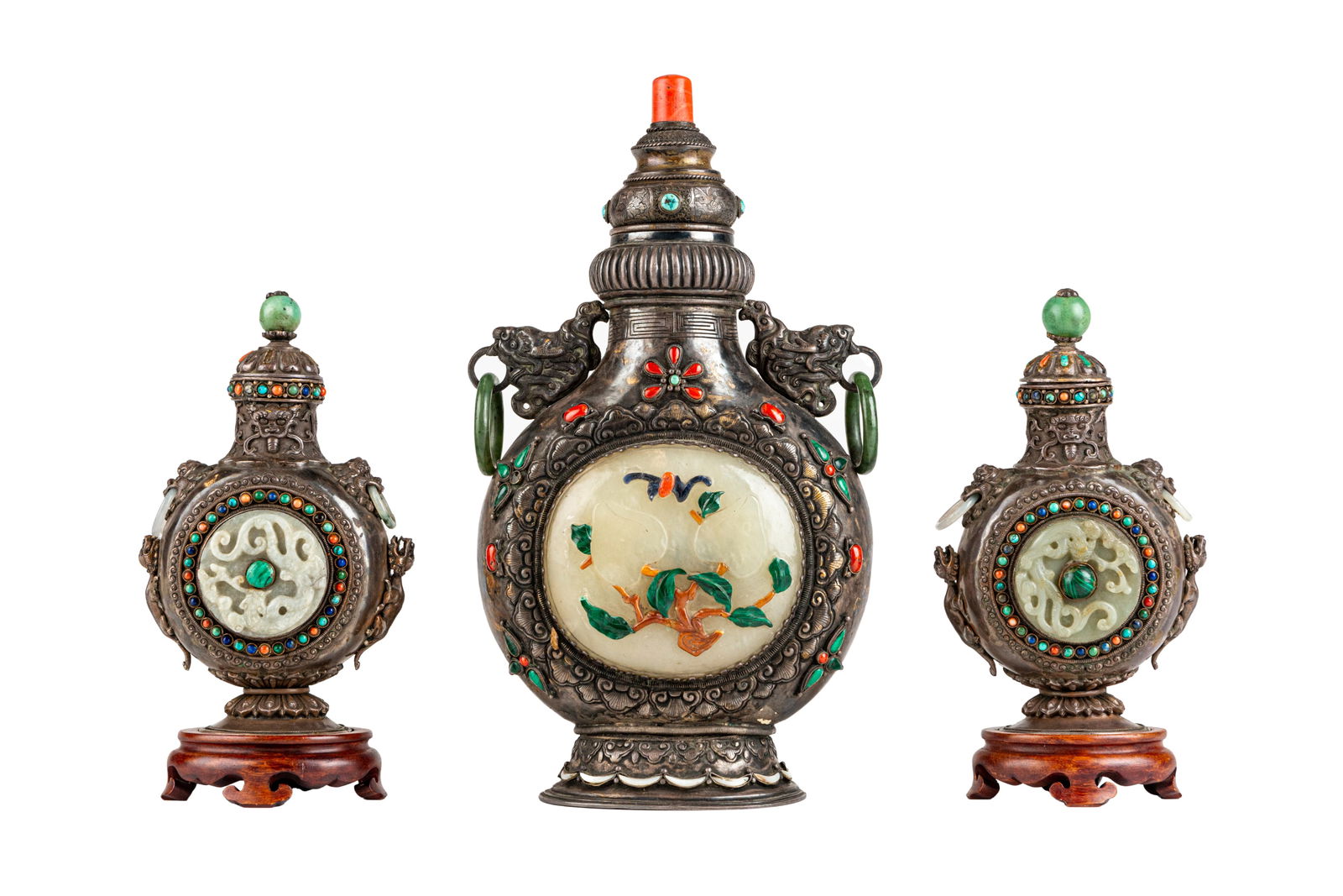 Set of Three Chinese Qing Jade and Silver Moon Flasks: Three Qing moon flasks in jade with inlay silver decor. The Jade medallions depict chi-dragons and peaches. Dated 19th century circa. Some damage to the lid of the smaller one. 