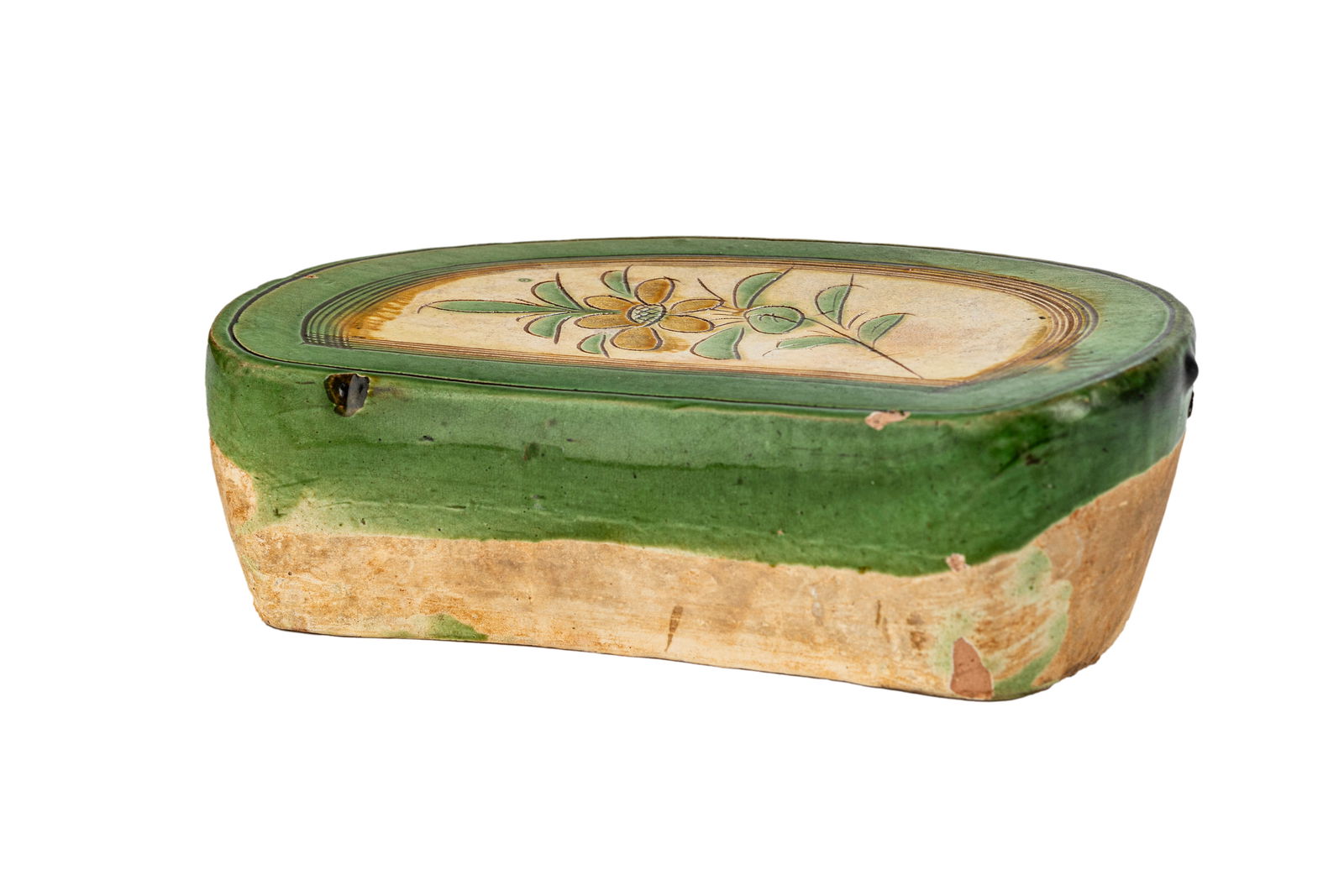 Chinese Song Cizhou Yao Green Glaze Pillow: Depicting a flower blossom in the shades of green. Dated circa 9th - 11th century. Measuring H 4 W 7.5 L 11.5 in Some chips and losses to the edges, cracks, and discoloration.