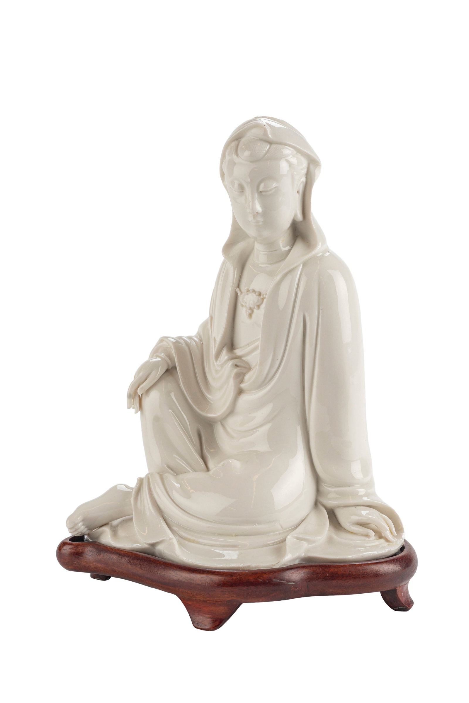 Chinese Blanc de Chine Porcelain Guan Yin: Guan Yin is seated, leaning on a stretched-out arm for support, and is looking down demurely. Republic Period Raised on a rosewood stand. 8.5 x 8 in Good Condition 