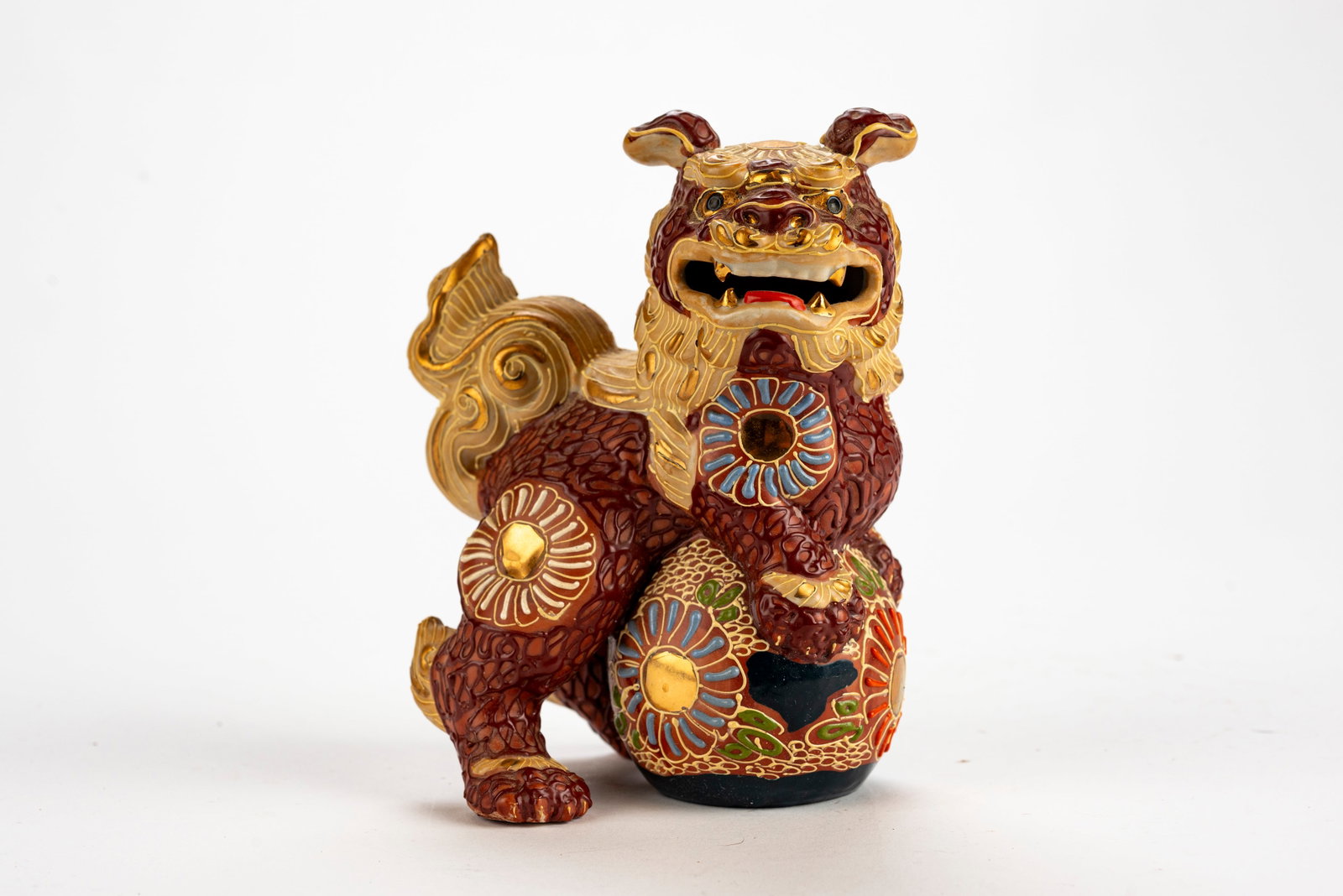 Japanese Satsuma Foo-Dog: The dog is looking out to the view while his front paws sit playfully on a ball. 20th Century 6.5 x 5 x 4 inches Good condition.