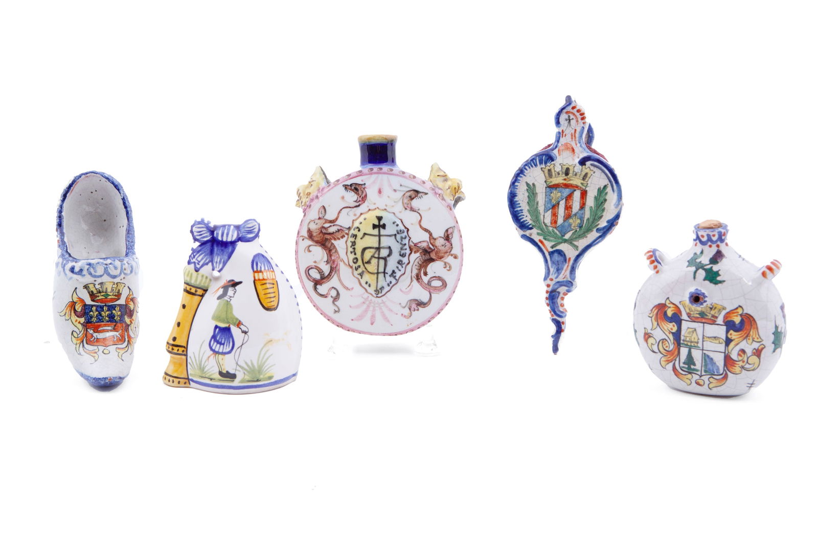 Collection of Five French Faience Quimper Trinkets: Including two flasks, one clog, one Baniou bell and one bellow pump. Some chips and scratches to the surface.