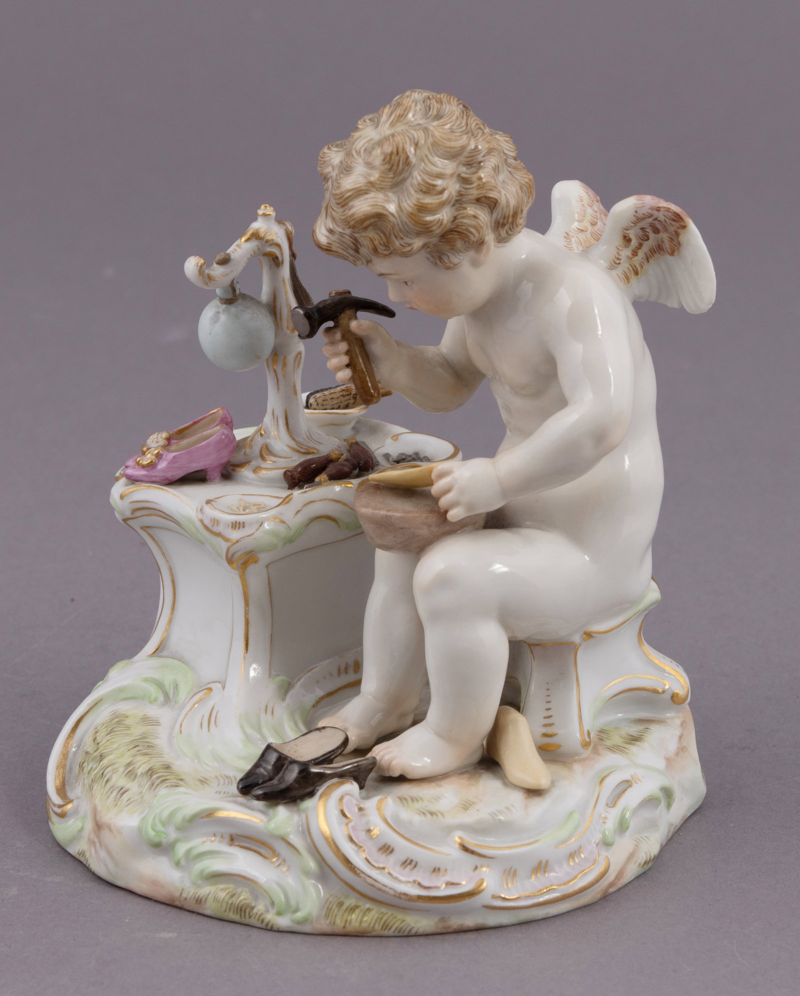 19th Century Meissen Figure of a Putti Making Shoes: A Putti shoemaker, marked with Meissen monogram on underside. Measuring H 5.5 W 4 inches Condition: overall good, no chips or damage.