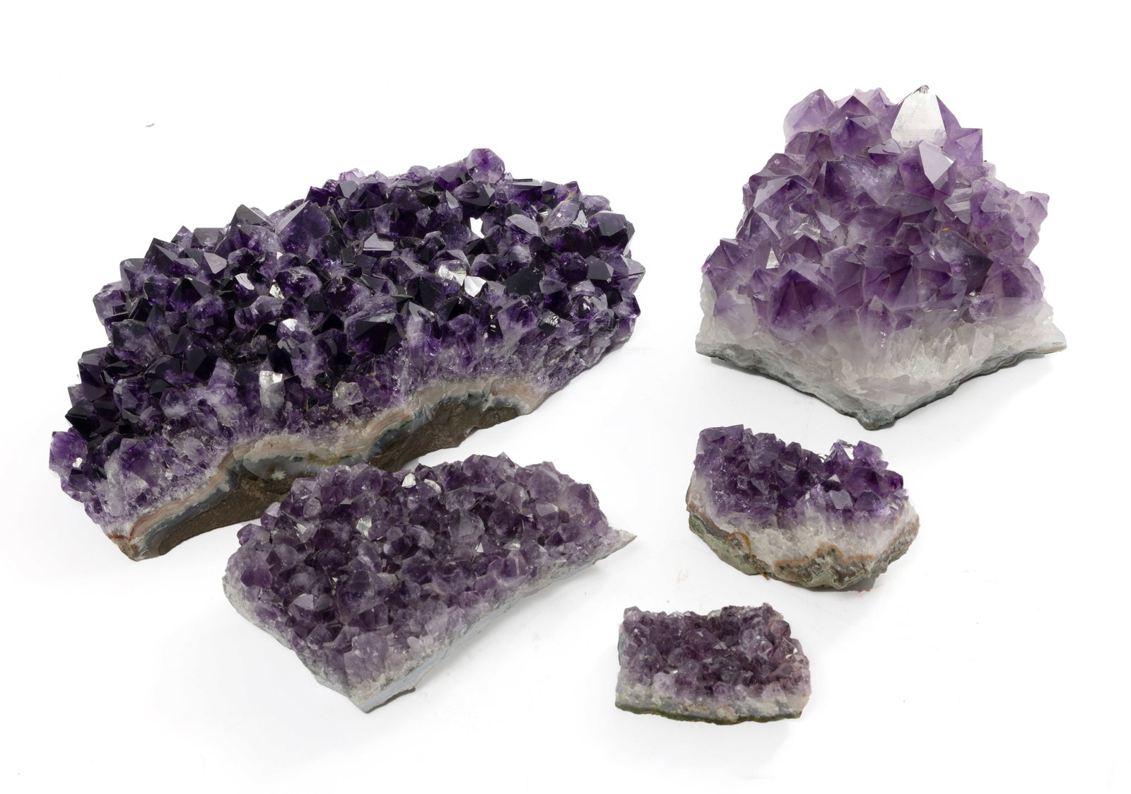 Set of Five Amethyst Geodes: This set of five amethyst geodes contains different sizes and shapes of crystals. The colors range from a deep purple to a lighter purple. One piece has felt pads on the bottom to prevent sliding and 