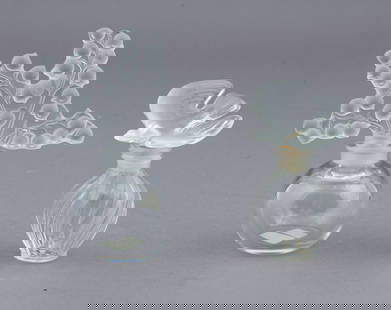 Pair of Lalique France Frosted and Crystal Art Glass Perfume Bottles: L'air Du Temps Nina Ricci bottle and Clairefontaine bottle. Both are signed - one with an acid stamp and the other with a label. The Clairefontaine bottle measures H 5 inches x W 4 inches The Ni