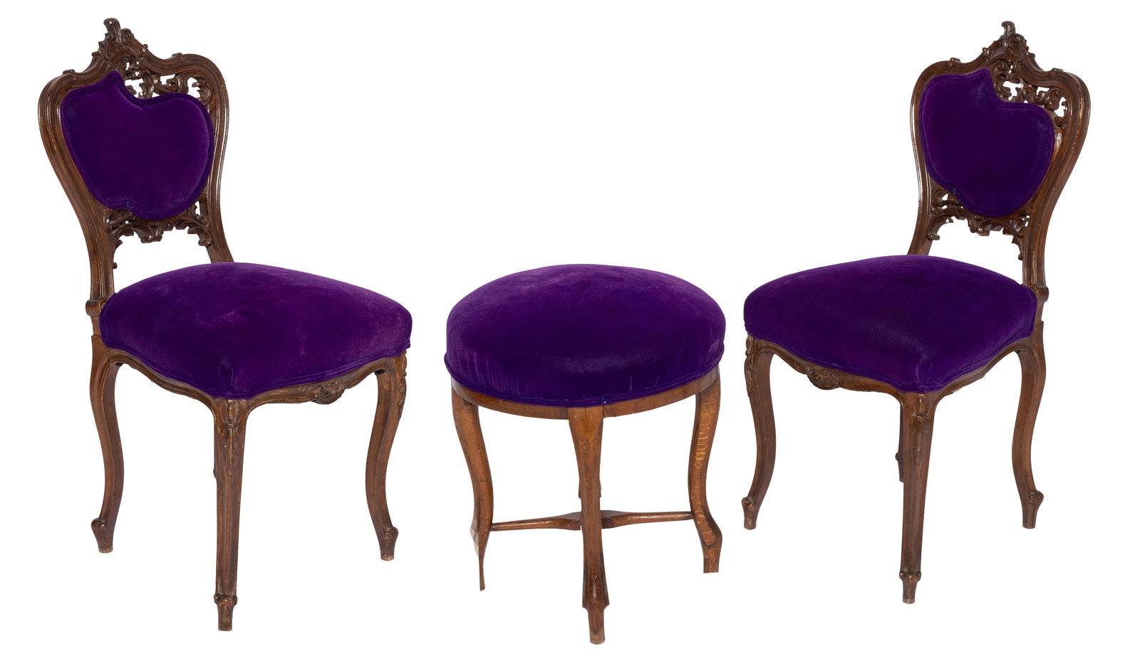 Pair of Purple Velvet Carved Wooden Chairs and Stool.: This is a pair of beautifully carved wooden chairs that have been upholstered in a purple velvet fabric. The stool is upholstered in the same fabric but does not share the same carvings as the chairs.