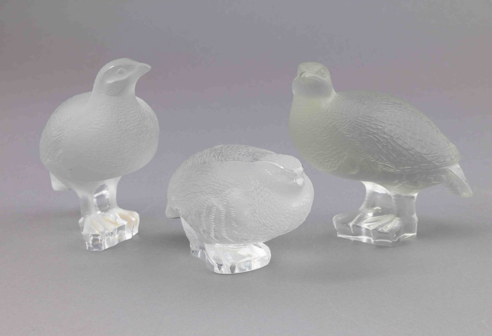 Set of Three Lalique Crouching Partridges: Three crystal partridges by Lalique. All are marked on the underside with the Lalique maker's mark. They measure H 5.5 W 5.5 D 3.5 inches. Condition: very good 