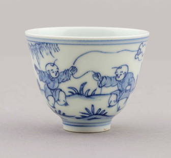 19th-Century Chinese Blue and White Cup: A Chinese blue and white cup is decorated with figures at play in a landscape scene. It has a six-character Chenghu mark on the underside and comes from the 19th-century Qing Dynasty. It measures H 2